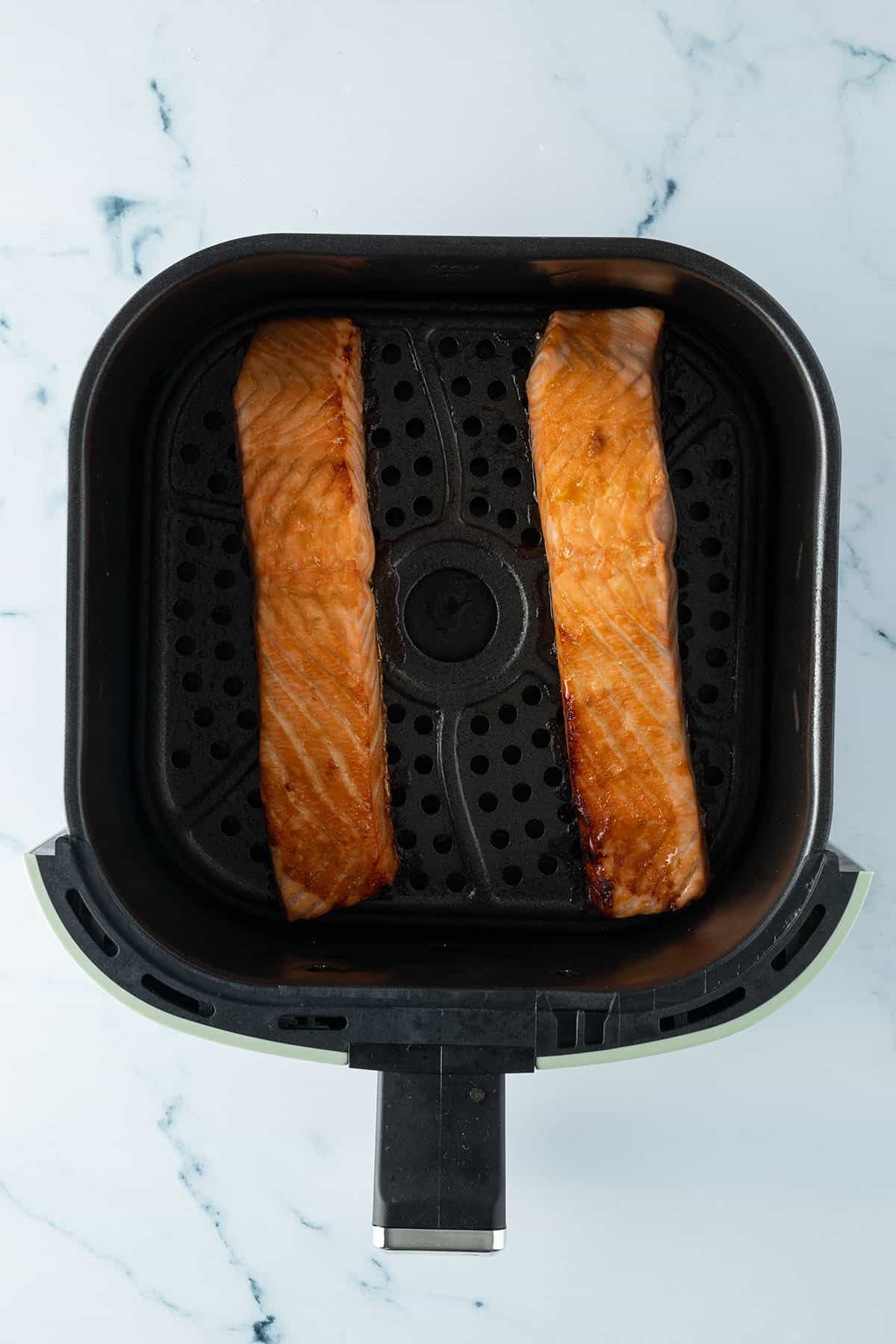 Fertige Lachsfilets in einem Airfryer.