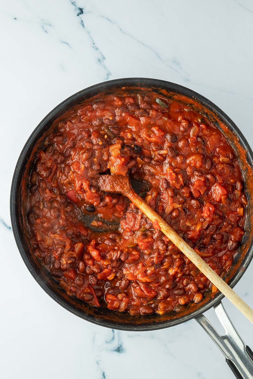 Cremige, dickfl&uuml;ssige Bohnen-Tomaten-Mischung in einer Pfanne.