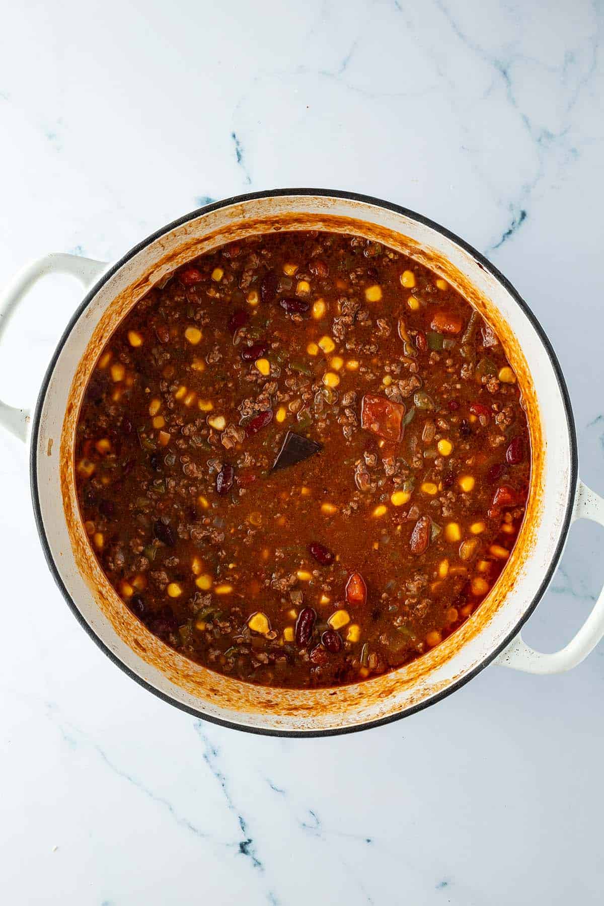 Chili con Carne nach einer Stunde kochen mit Mais, Bohnen und einem St&uuml;ck Schokolade.