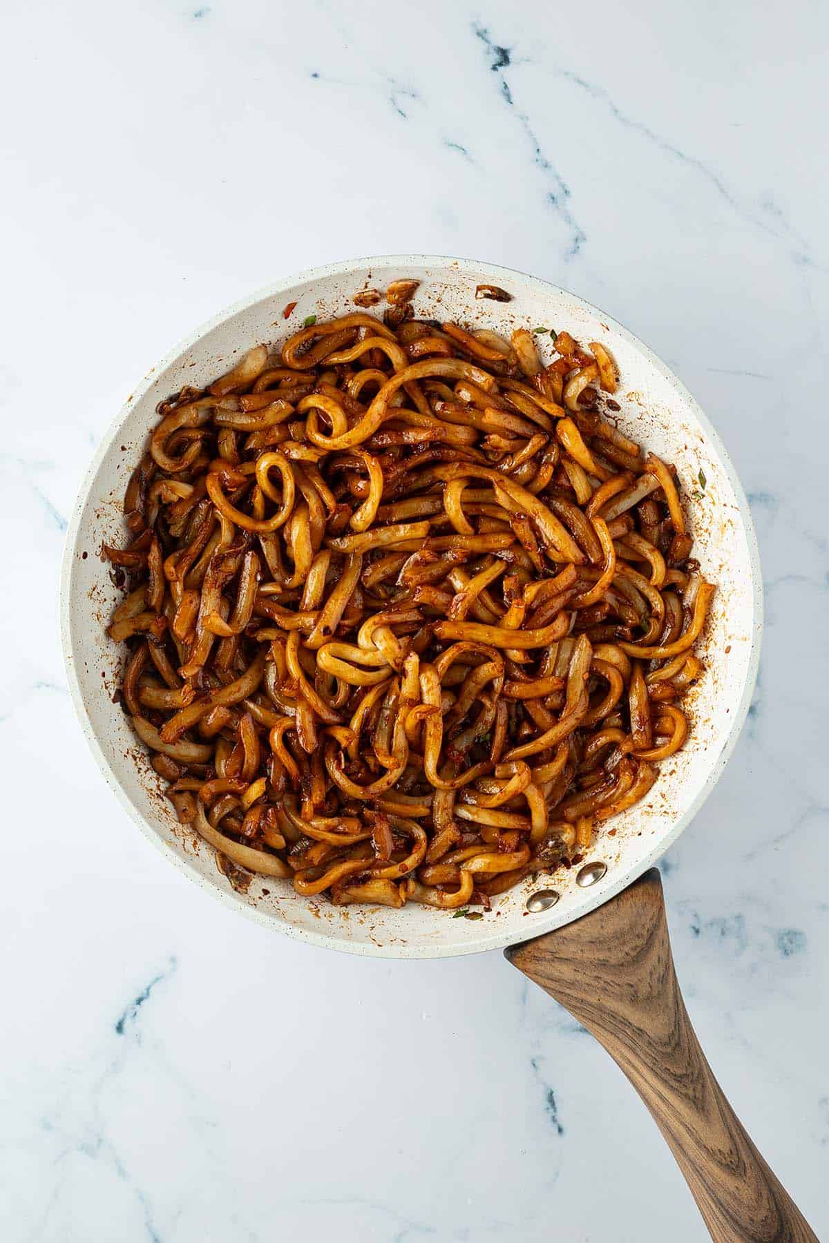 Chili Udon Nudeln in einer Pfanne mit Sojasauce.