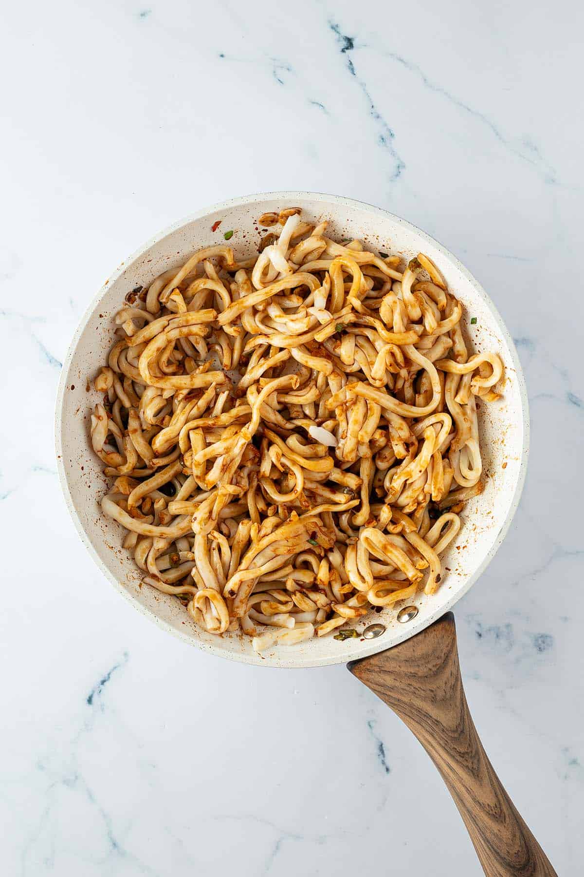 Vorgekochte Udon Nudeln und Sauce wurden mit in die Pfanne gegeben.