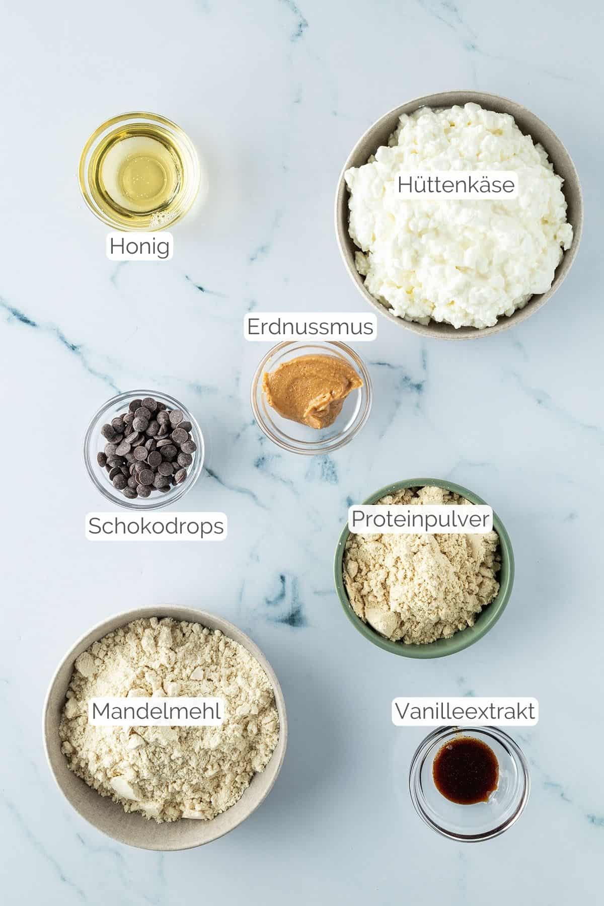 Foto aller Zutaten mit jeweiligen Textbeschriftungen, die f&uuml;r Cottage Cheese Cookie Dough ben&ouml;tigt werden.
