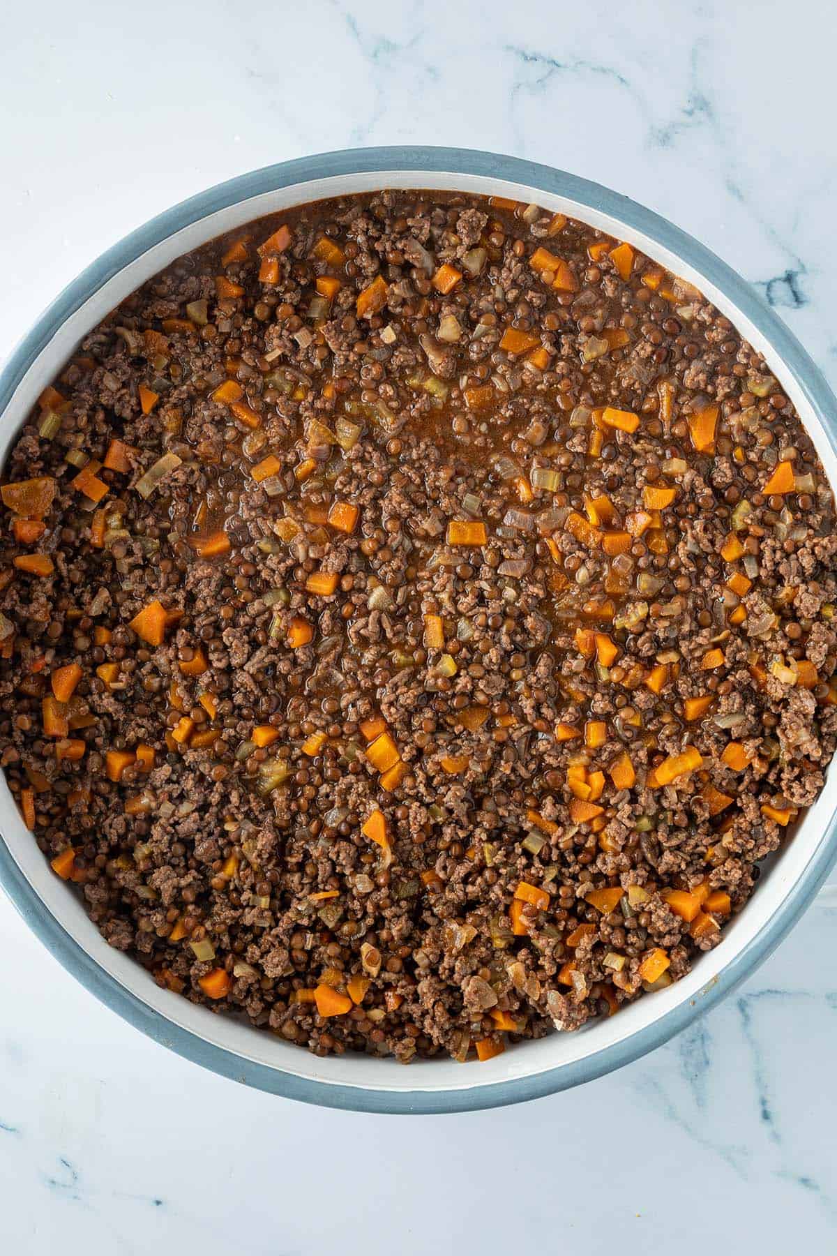 Hackfleischschicht f&uuml;r den Cottage Pie in einer runden, gro&szlig;en Auflaufform.