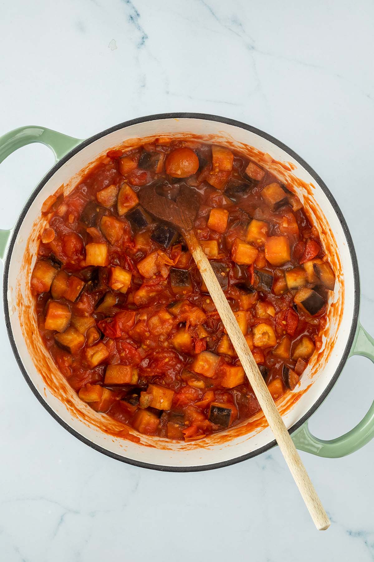 Vogelperspektive auf einen Topf mit Auberginenw&uuml;rfeln in einer Tomatensauce.