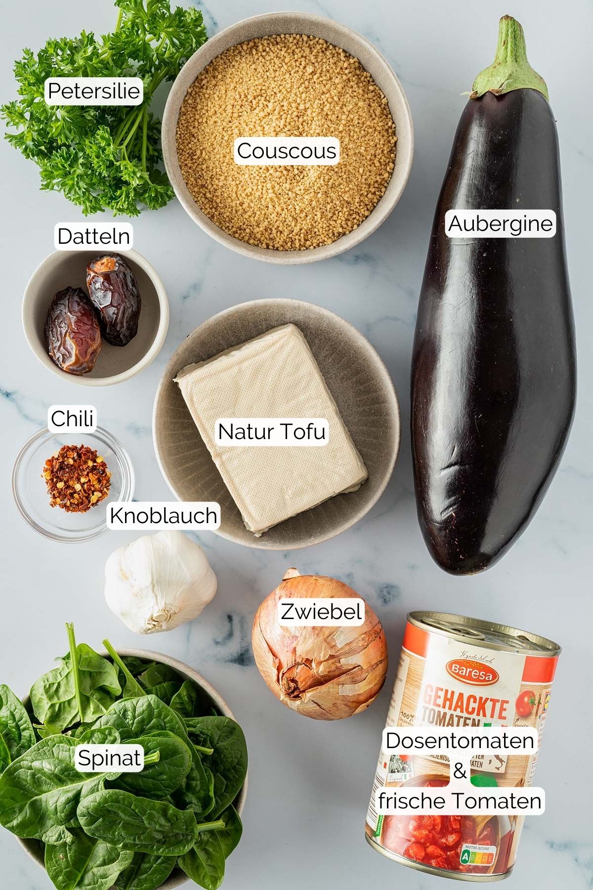Foto alle Zutaten mit jeweiligen Textbeschriftungen, die f&uuml;r die Couscous Gem&uuml;se Pfanne ben&ouml;tigt werden.