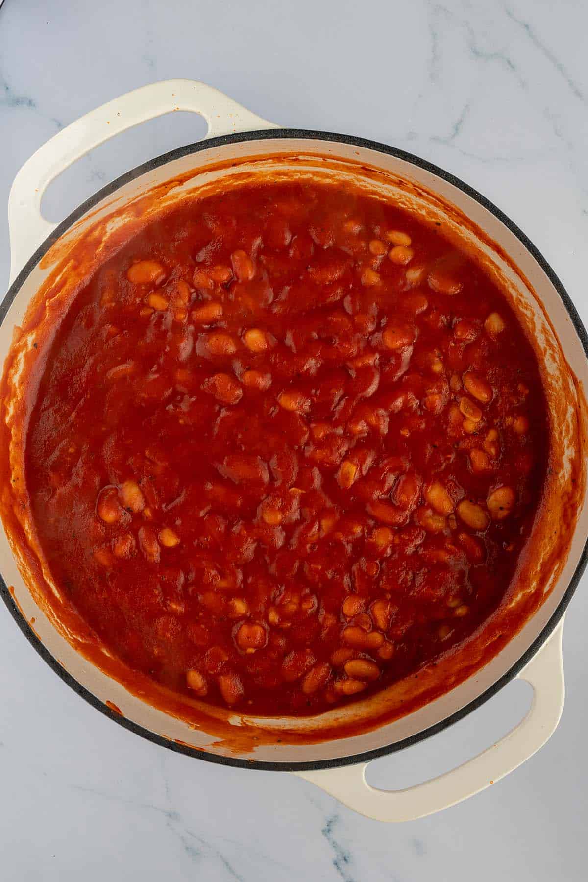 Wei&szlig;e Bohnen kochen in eine s&auml;migen Tomatensauce.