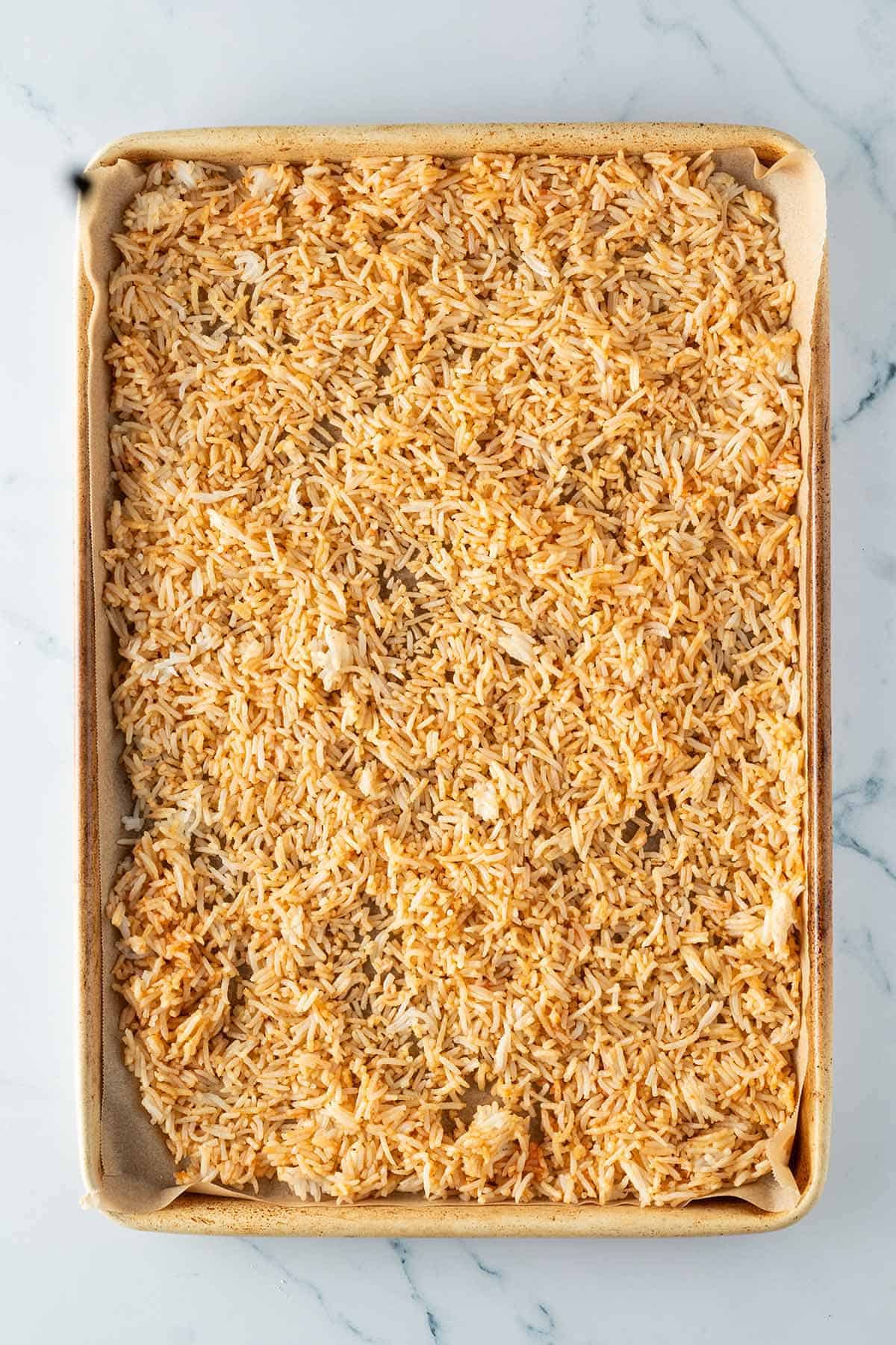 Geraspelter Tofu auf ein mit Backpapier ausgelegtem Blech.