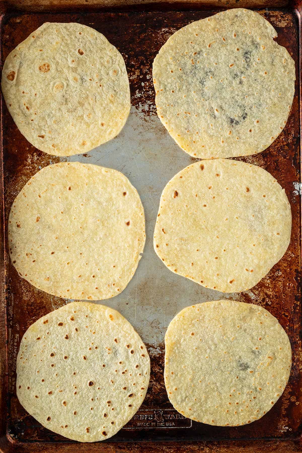 Tortillas auf einem Backblech als Vorbereitung f&uuml;r knusprige Crispy Tacos.