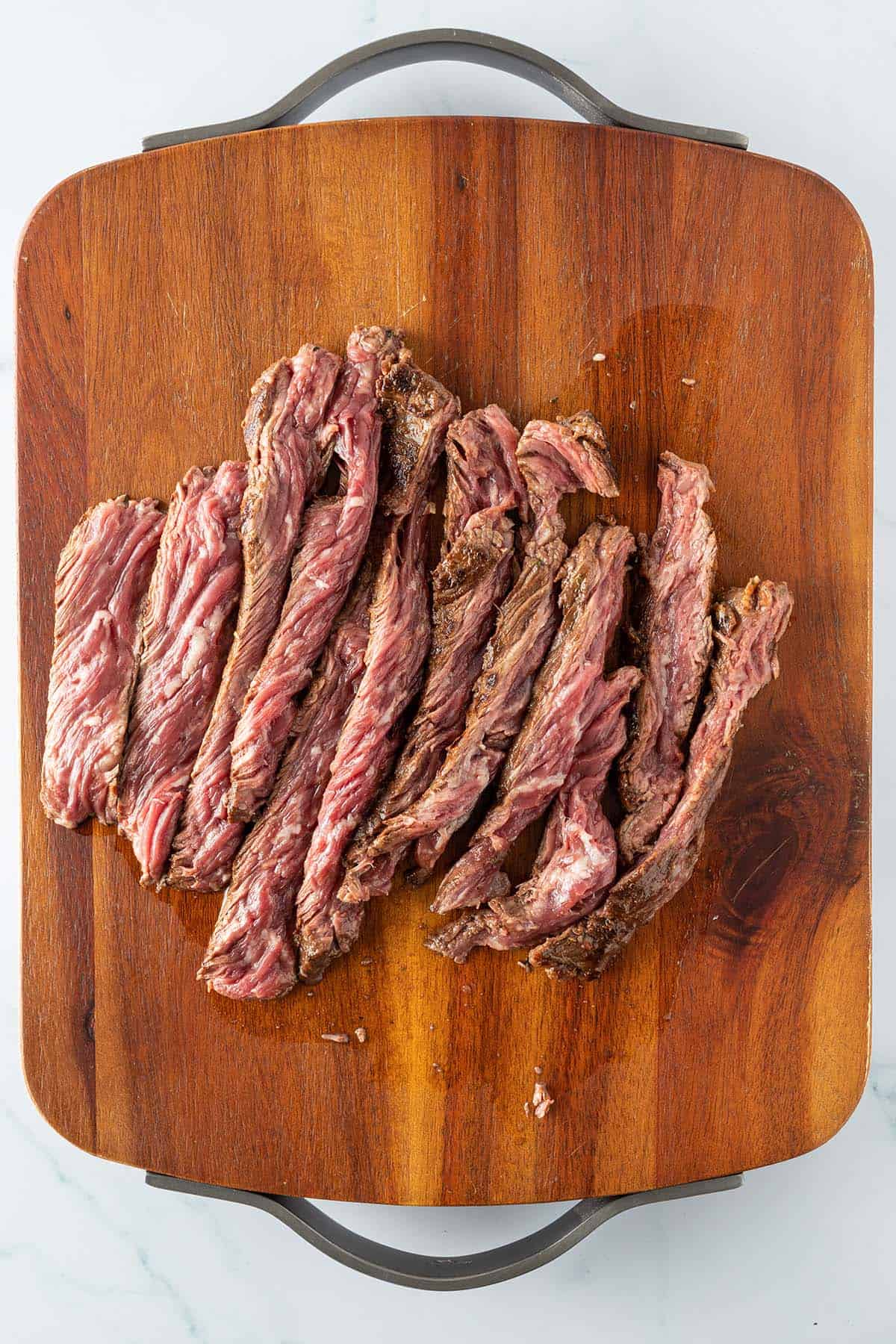 Medium rare angebratenes und in Streifen geschnittenes Steak auf einem Blech.
