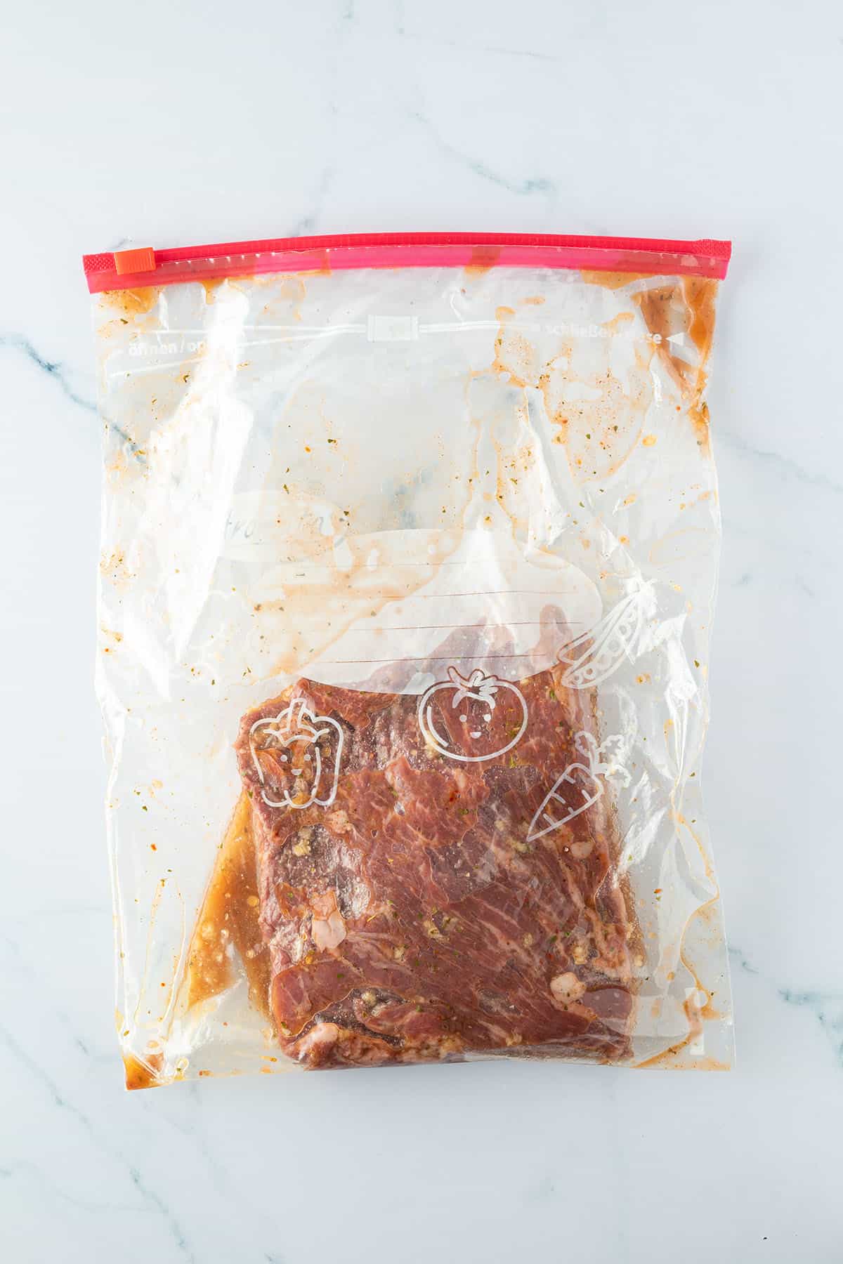 Ein rohes St&uuml;ck Rindfleisch in einem Zippbeutel mit einer Marinade.