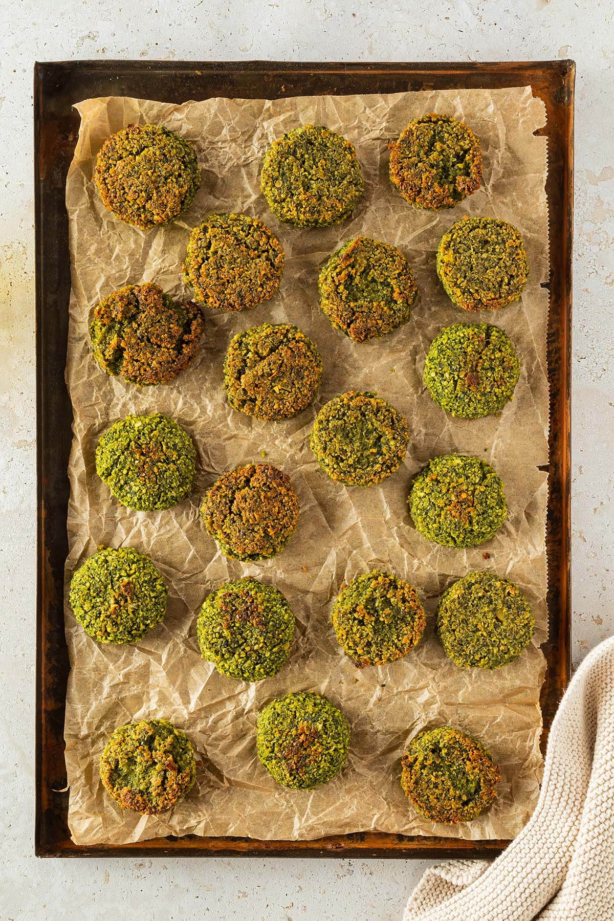 Knusprig gebackene Falafel aus dem Backofen auf einem Blech mit Backpapier.
