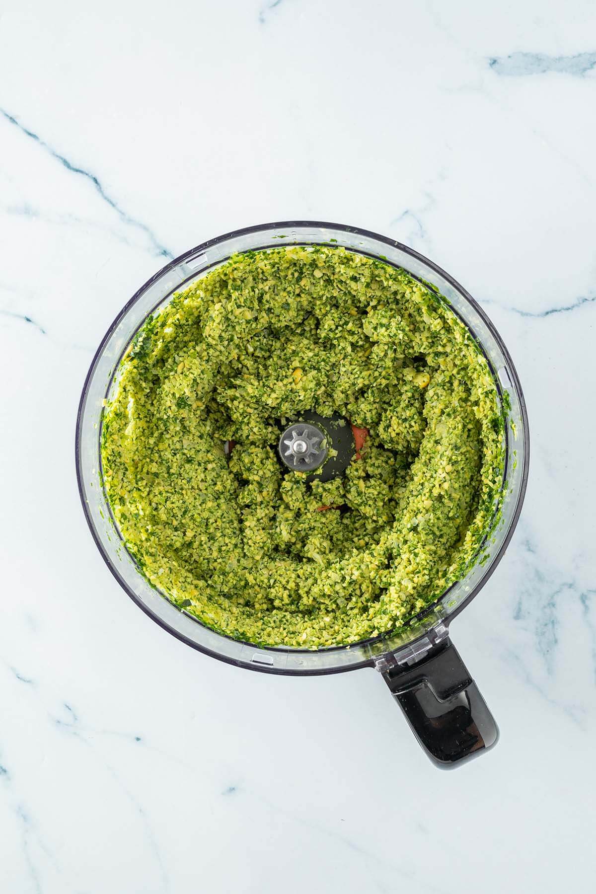 Hellgrüner Falafelteig in einem Mixer.