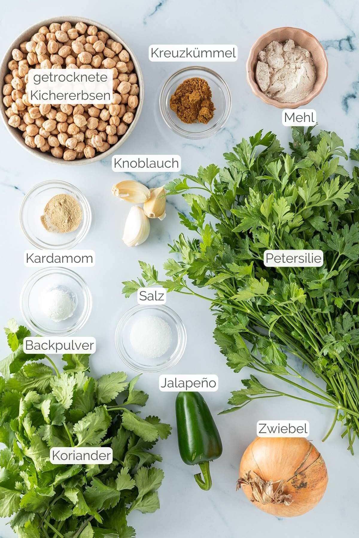 Foto aller Zutaten mit jeweiligen Textbeschriftungen, die für Falafel im Ofen benötigt werden.