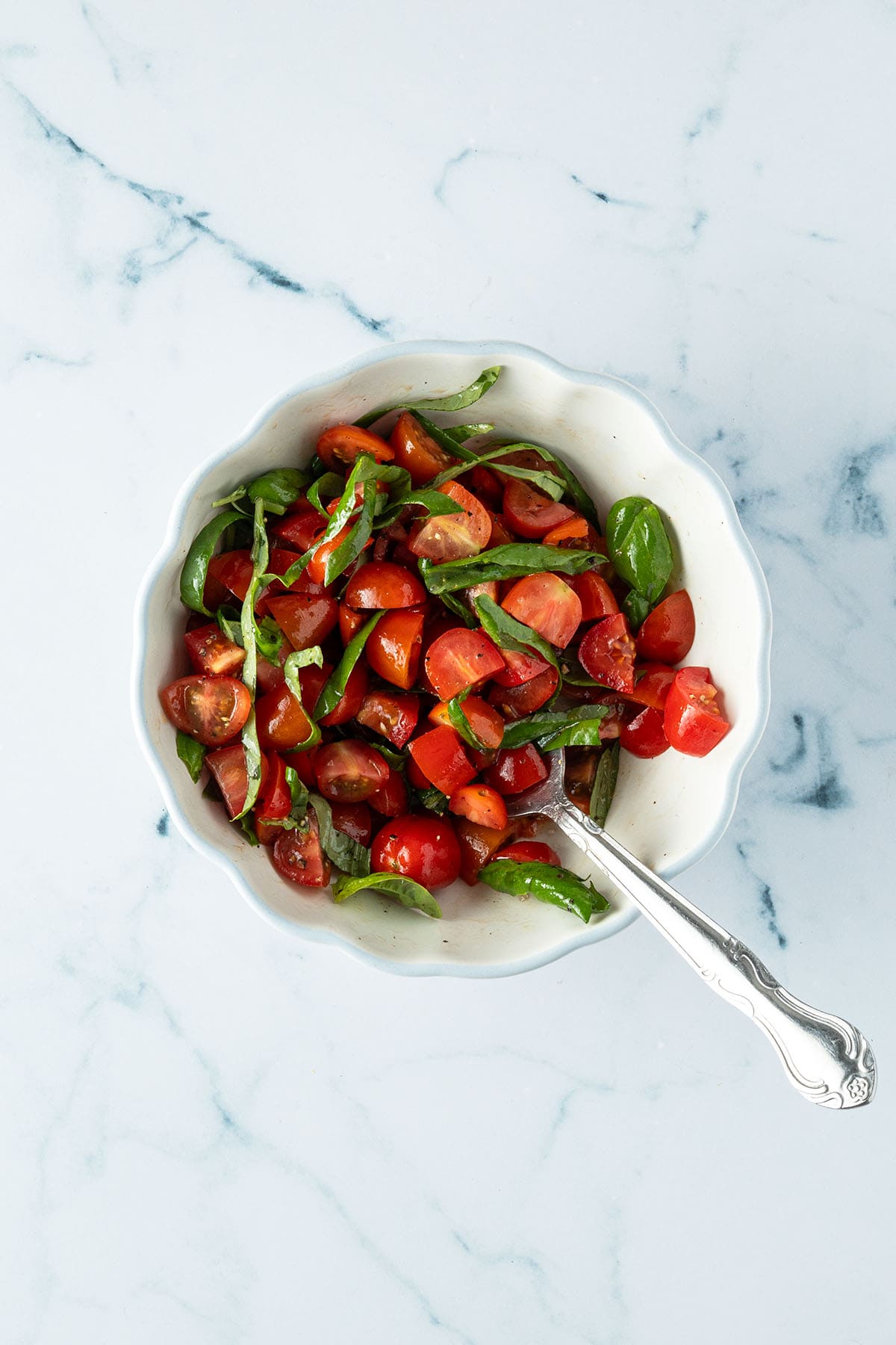 Tomatenw&uuml;rfel und Basilikum in einer kleinen Sch&uuml;ssel.