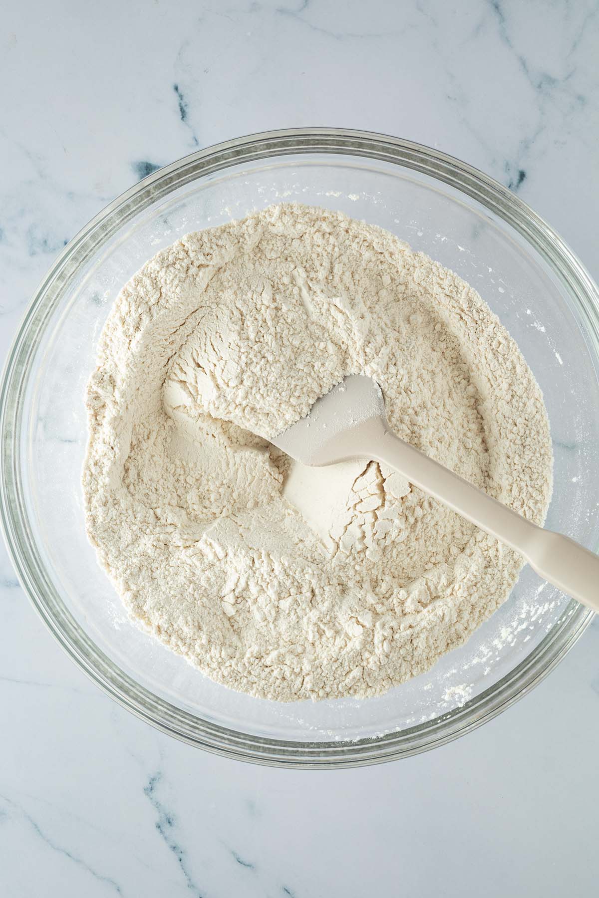 Mehl, Salz und Trockenhefe werden f&uuml;r den Focaccia Teig in einer gro&szlig;en Glassch&uuml;ssel verr&uuml;hrt.