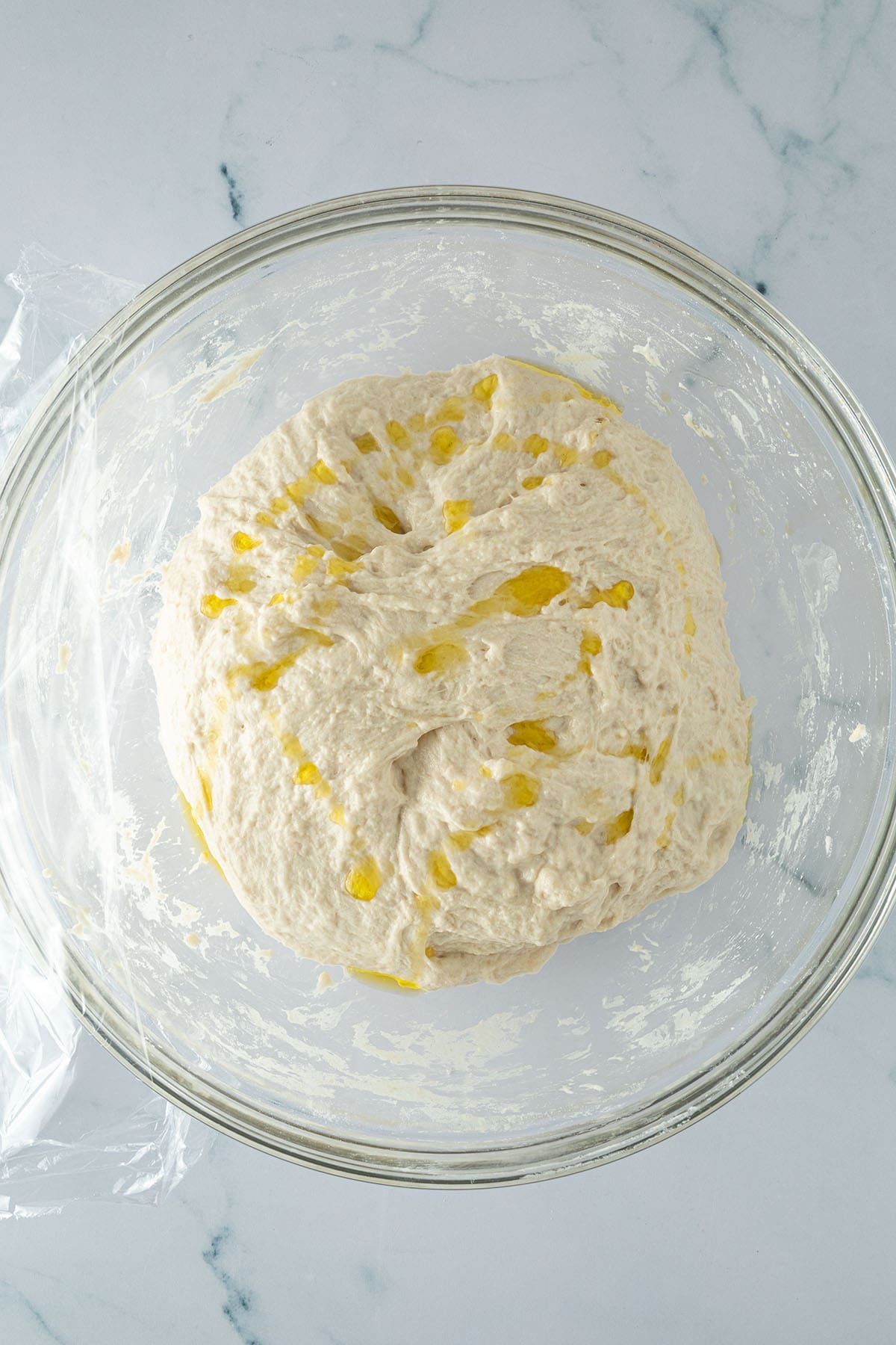 Focaccia-Teig mit Oliven&ouml;l in einer Glassch&uuml;ssel vor der langen Gehzeit im K&uuml;hlschrank.