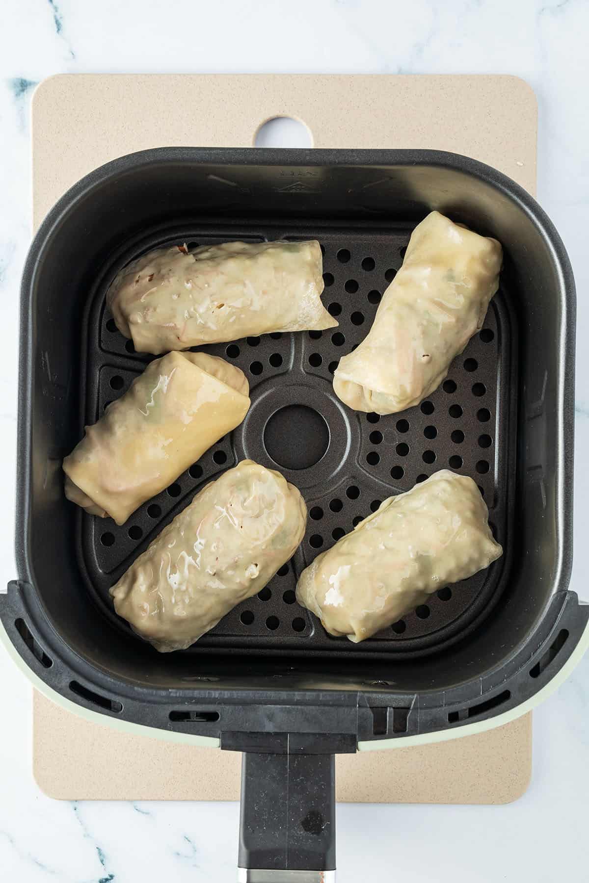 F&uuml;nf Fr&uuml;hlingsrollen in dem Korb einer Hei&szlig;luftfrittuese.