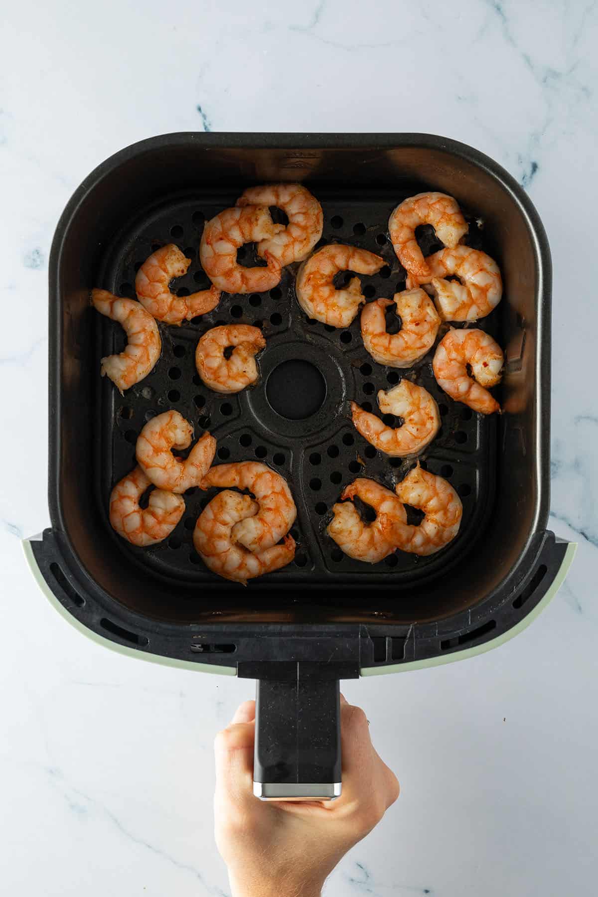 Fertig gegarte Garnelen in einem Airfryer Korb.