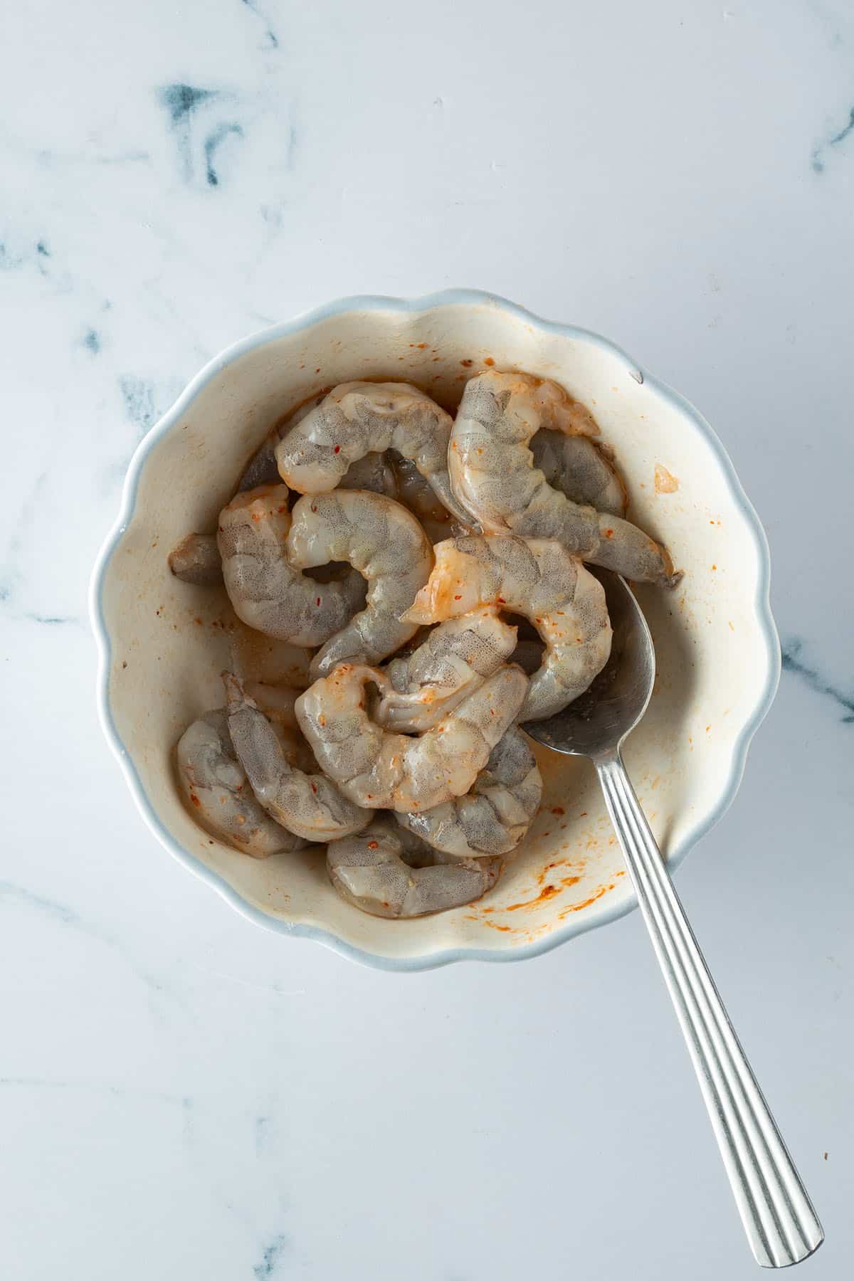 Mit Curry Paste marinierte Garnelen in einer Sch&uuml;ssel.