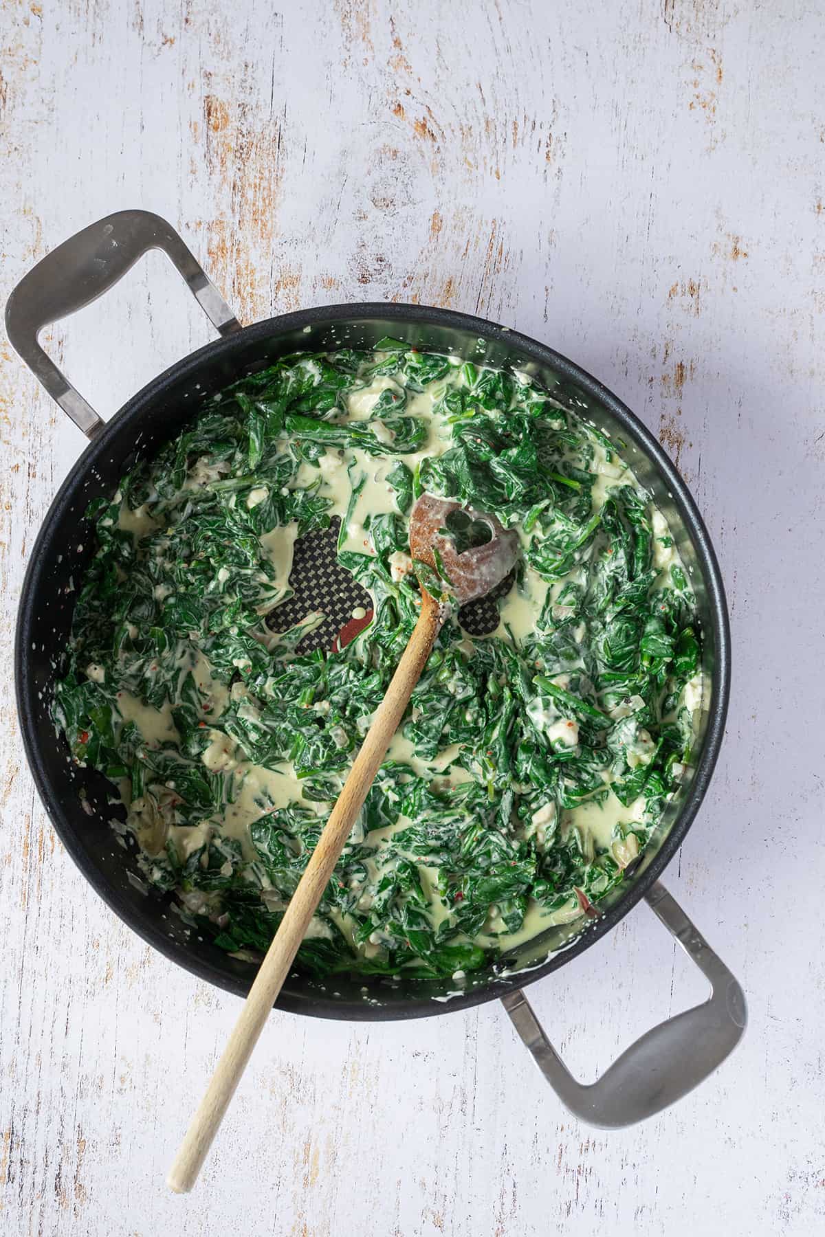 Cremige Spinat-Feta-F&uuml;llung in einer Pfanne.