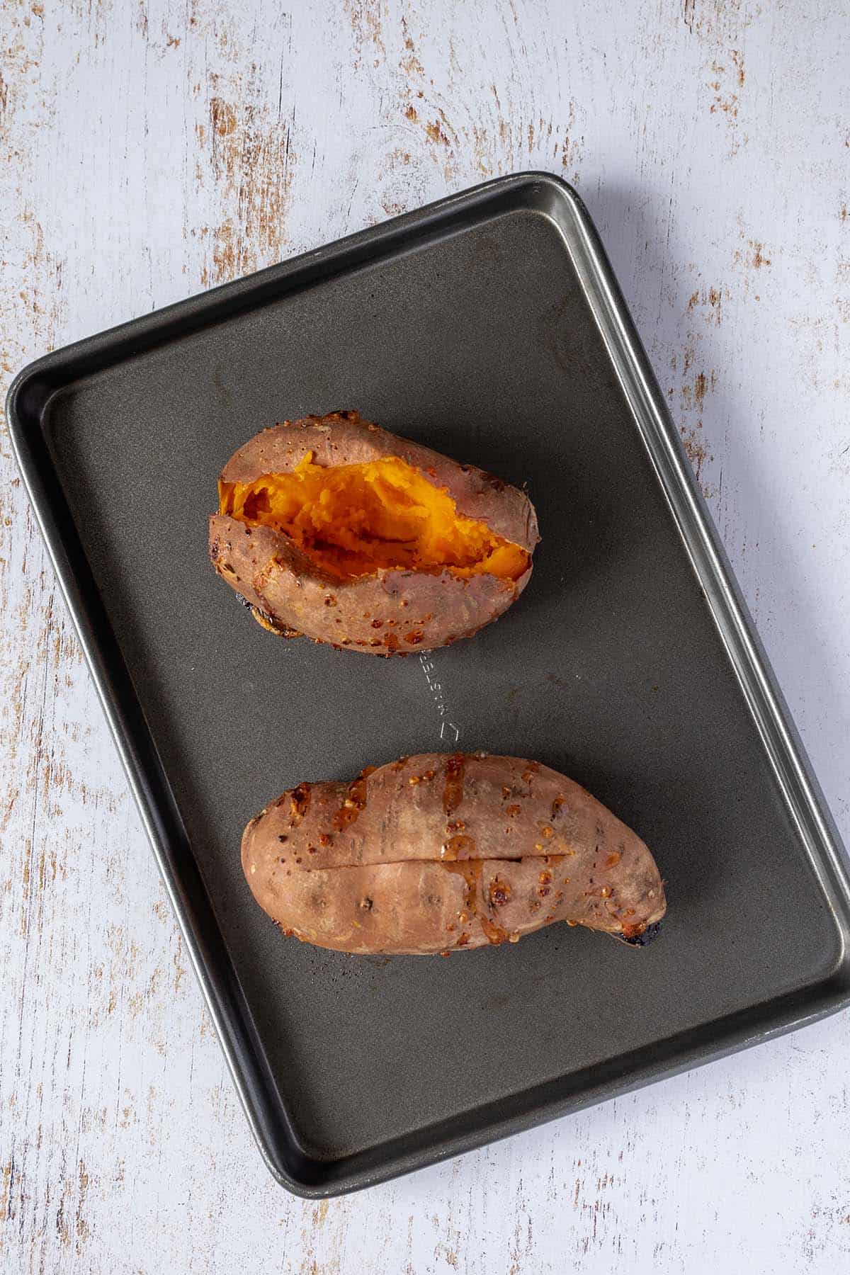 Gebackene S&uuml;&szlig;kartoffeln auf einem Blech.