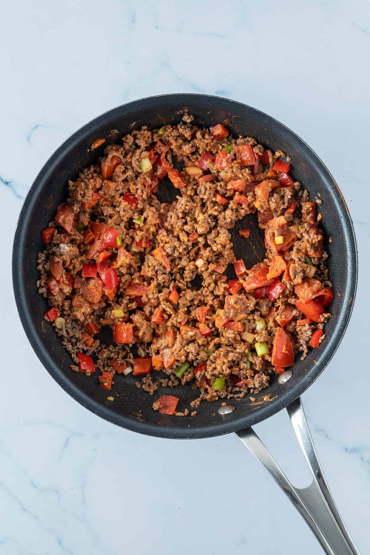 Fertige Hackfleisch-Paprika-Füllung mit einer cremigen Tomaten-Frischkäsesauce in einer Pfanne.