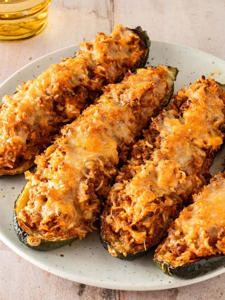 &Uuml;berbackene, gef&uuml;llte Zucchinih&auml;lften mit Reis, Hackfleisch und geschmolzenem K&auml;se auf einem Teller serviert.
