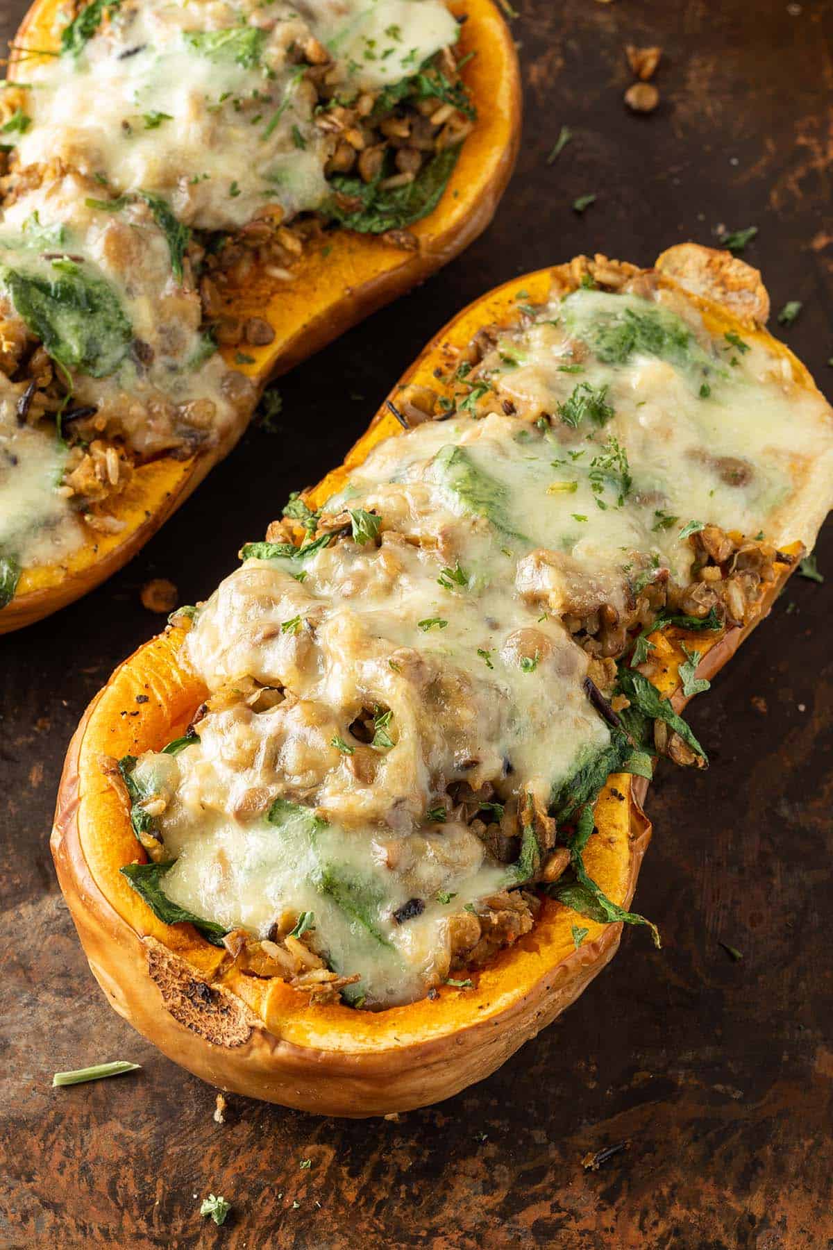 Mit Reis und Linsen gef&uuml;llter Butternut K&uuml;rbis mit geschmolzenem Mozzarella darauf.