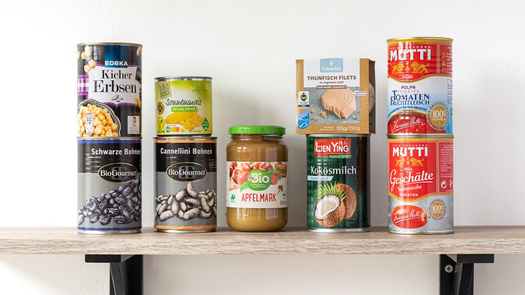 Gesunde Lebensmittel f&uuml;r die Vorratskammer: H&uuml;lsenfr&uuml;chte, Kokosmilch, Thunfisch, Apfelmark und Dosentomaten auf einem Regal