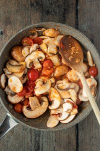 Tomaten und Champignons werden in einer Pfanne angebraten