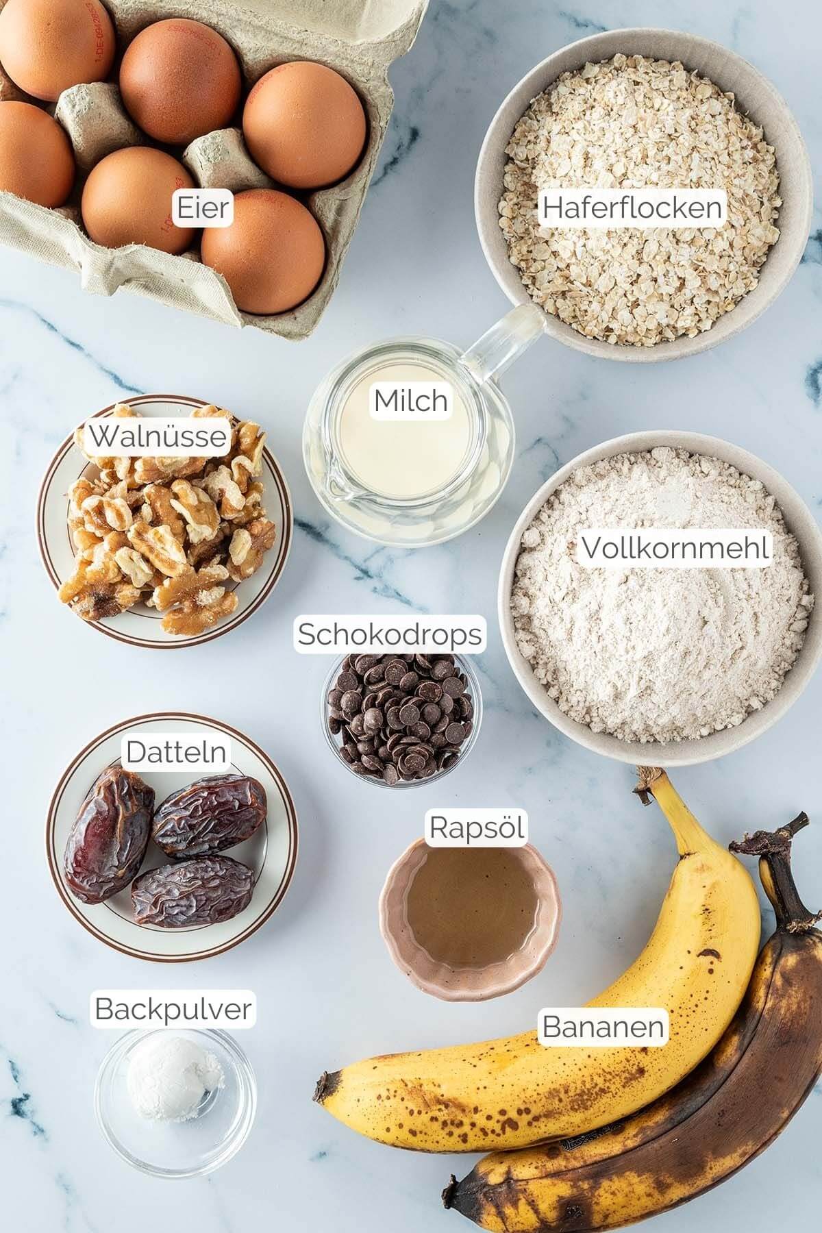 Foto aller Zutaten mit jeweiligen Textbeschriftungen, die f&uuml;r gesunde Bananen Muffins ben&ouml;tigt werden.