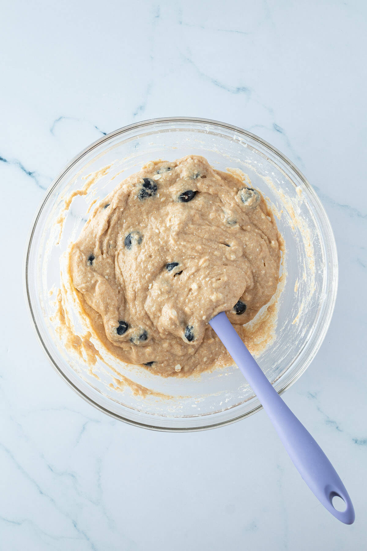 Teig f&uuml;r die Blaubeer-Muffins mit einem Teigschaber in einer Glassch&uuml;ssel.