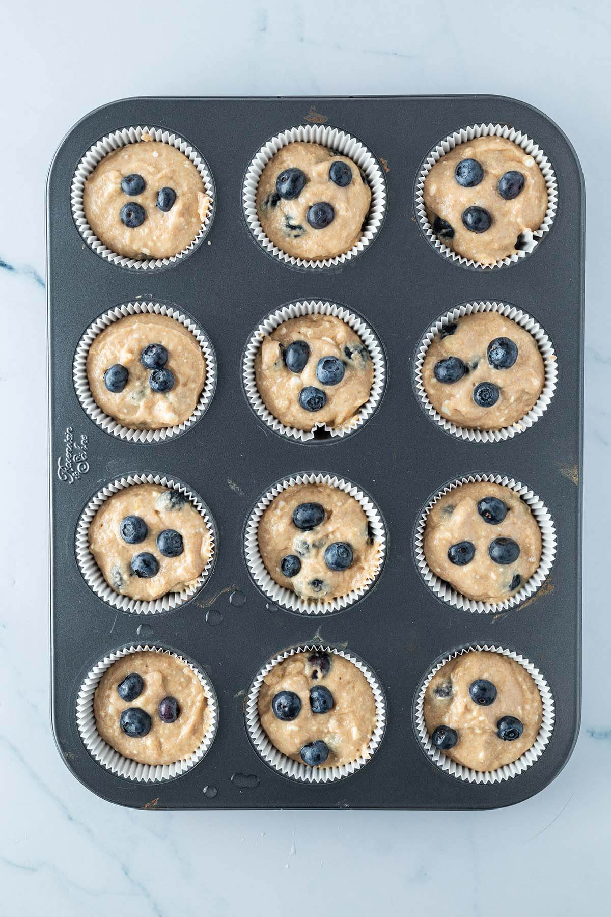 Blaubeermuffins vor dem Backen in einem Muffinblech.