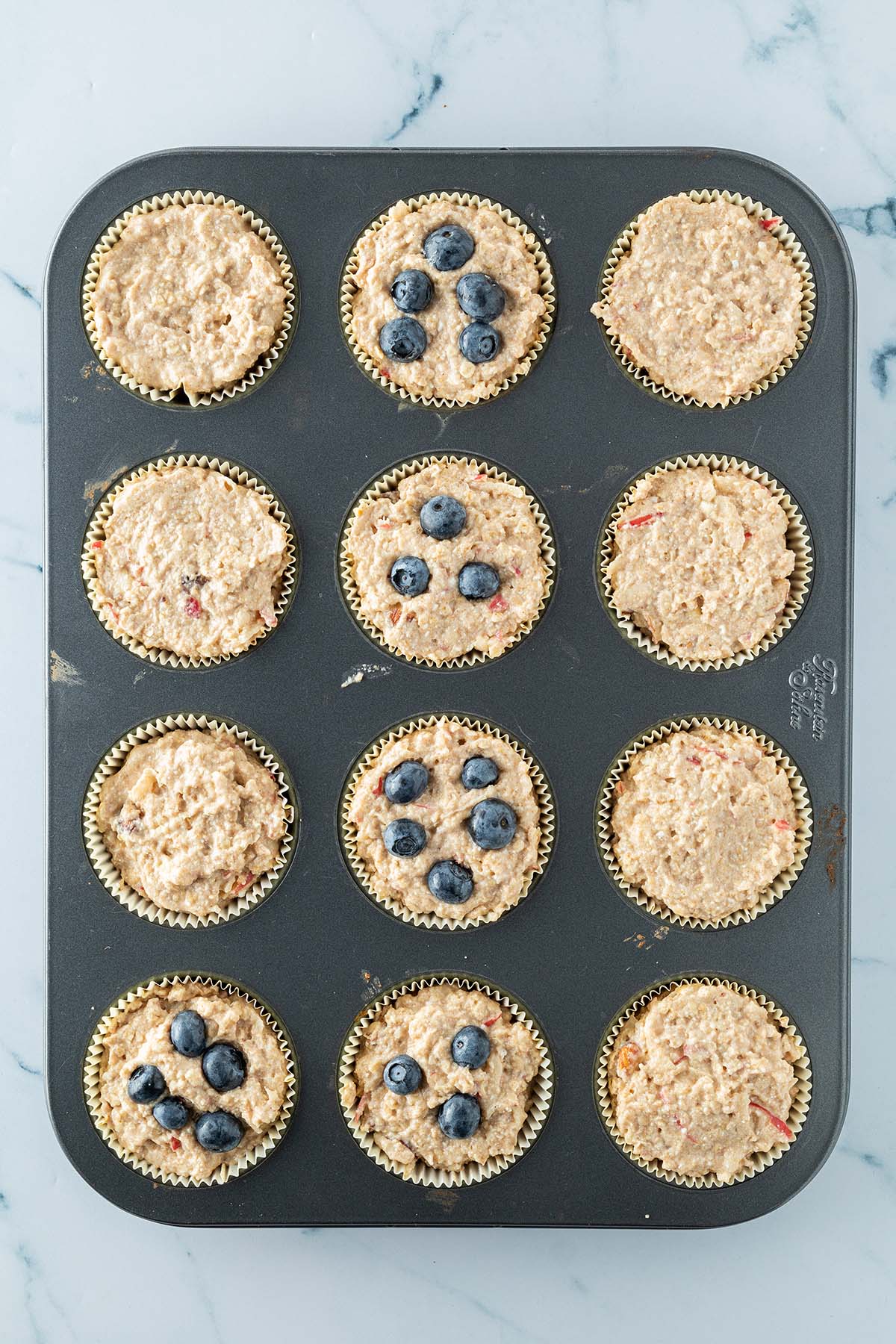 Fr&uuml;hst&uuml;cksmuffins in einem Muffinblech vor dem Backen.