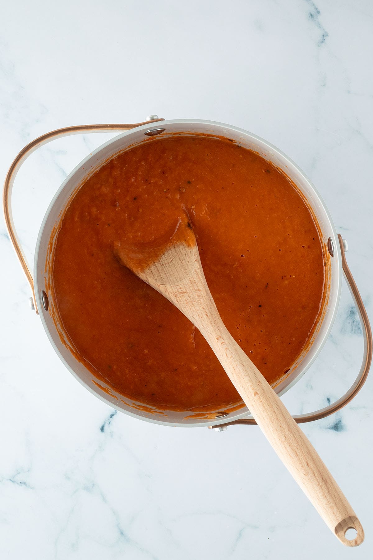 Fertige Tomatensuppe in einem Topf mit Kochl&ouml;ffel.