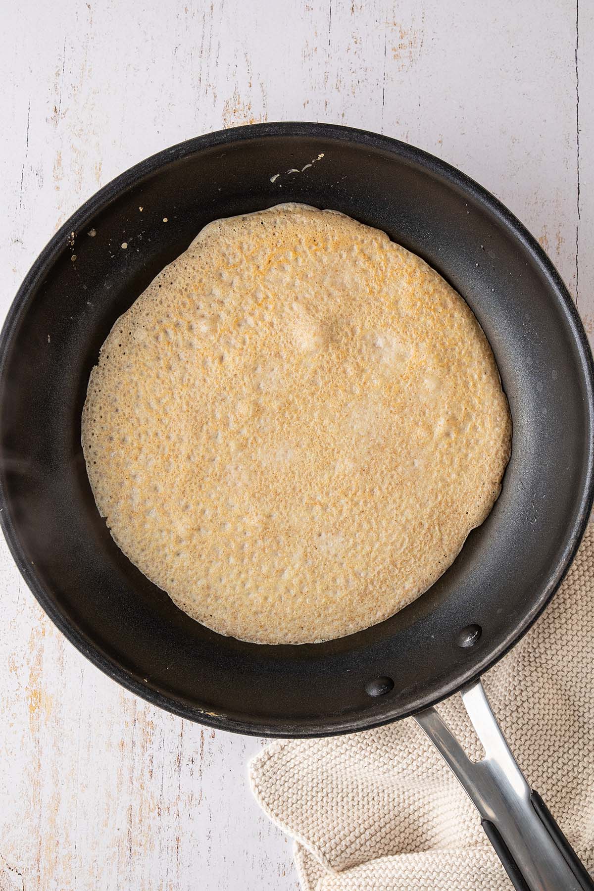 Vogelperspektive auf eine Pfanne mit einem Pfannkuchen nach dem Wenden.