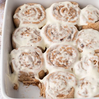 Auflaufform mit elf mit Frischk&auml;se-Frosting &uuml;berzogenen Zimtschnecken.