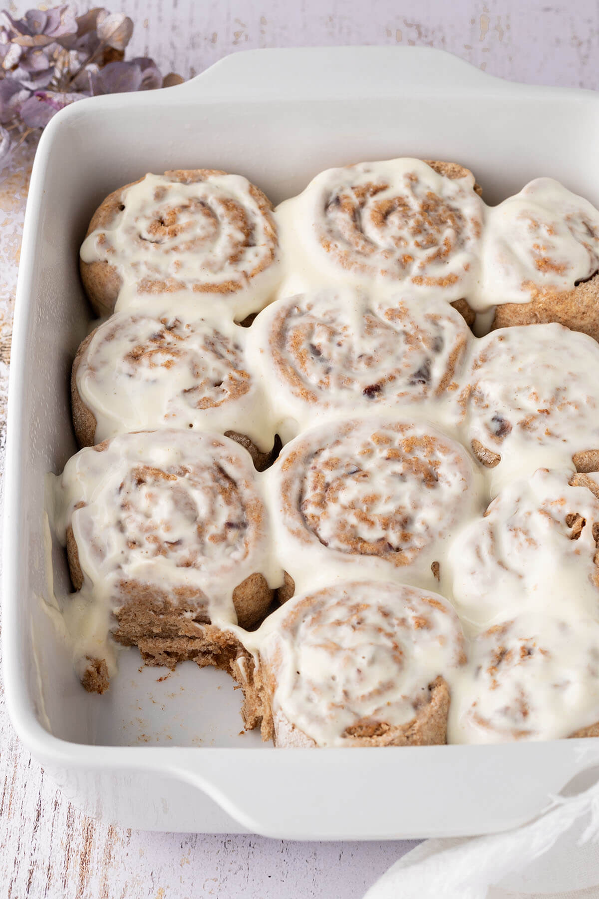 Auflaufform mit elf mit Frischk&auml;se-Frosting &uuml;berzogenen Zimtschnecken.