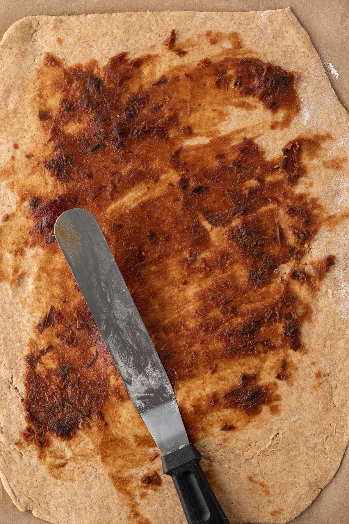 Ausgerollter Hefeteig wird mit einem Dattelp&uuml;ree bestrichen.