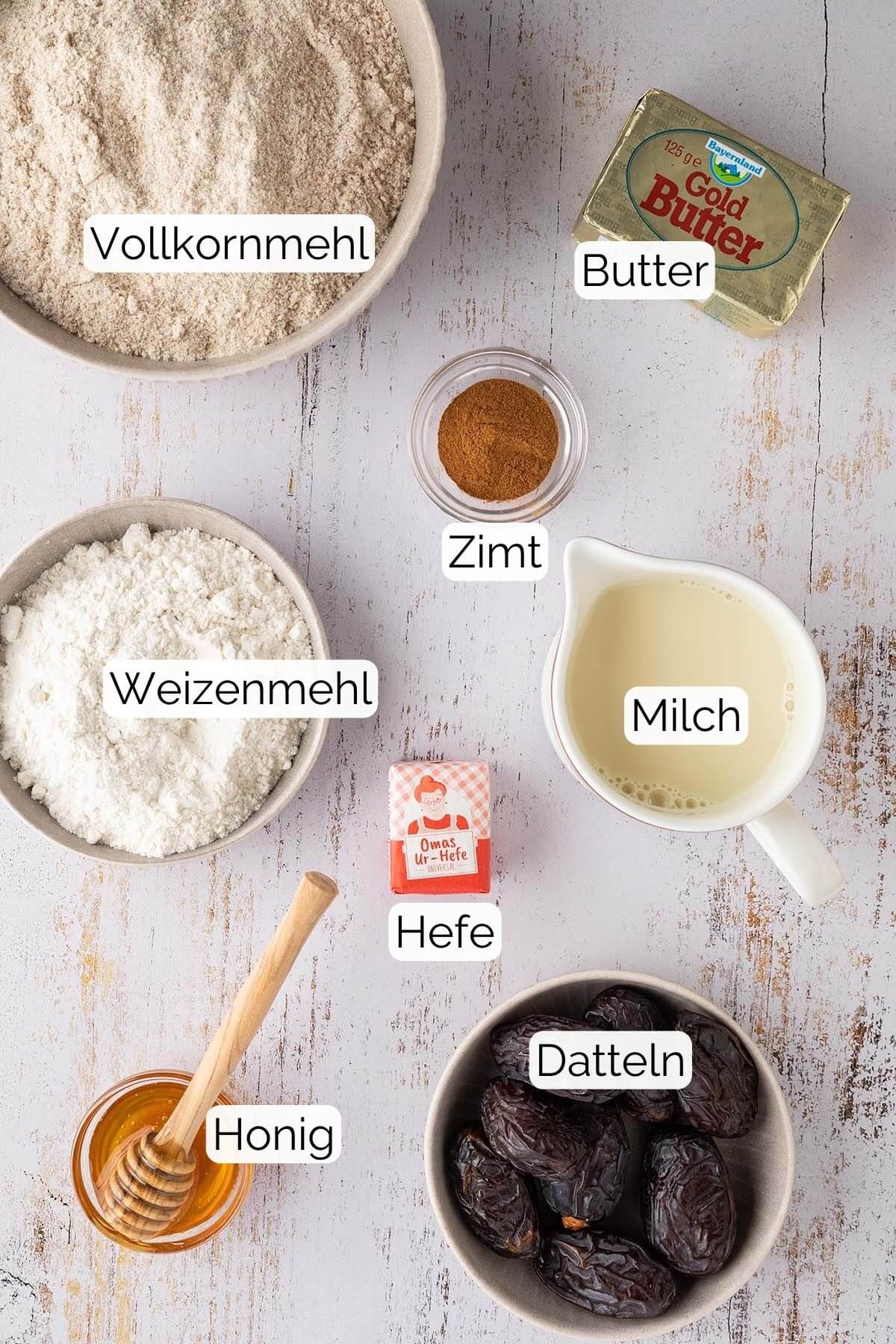Bild aller Zutaten, die f&uuml;r den gesunden Zimtschneckenteig und -F&uuml;llung ben&ouml;tigt werden, inklusive zugeh&ouml;riger Textlabels.