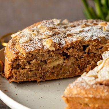 Gesunder Apfelkuchen ohne Zucker und mit wenig Kalorien aufgeschnitten auf einem Teller.