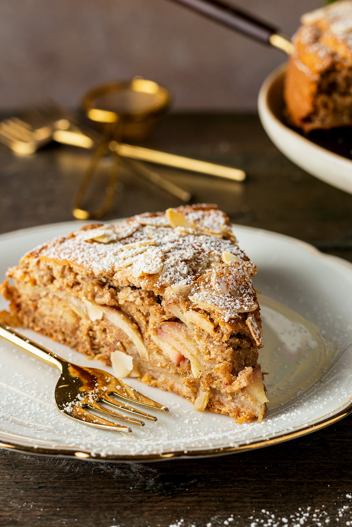 Ein St&uuml;ck von dem gesunden Apfelkuchen ohne Zucker auf einem wei&szlig;en Teller mit einer Kuchengabel daneben.