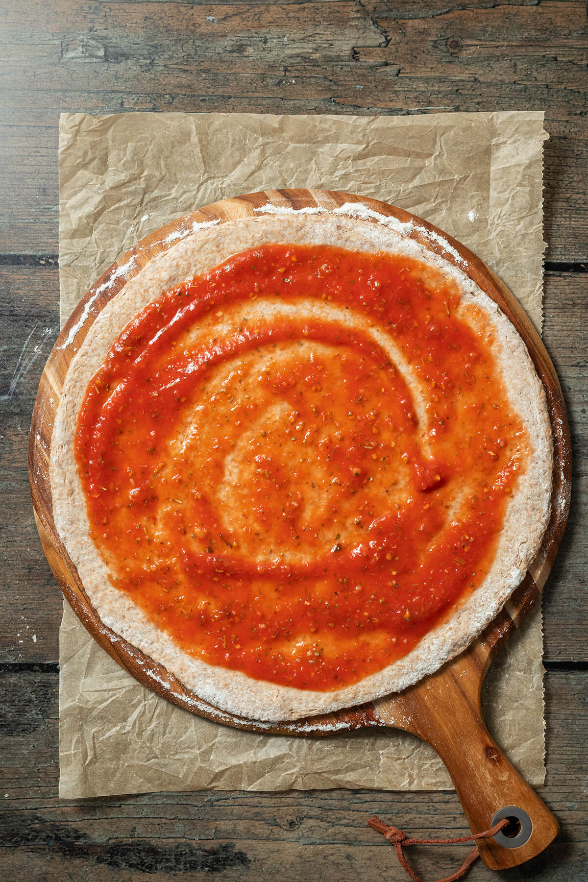 Pizzateig mit Tomatensauce bestrichen.
