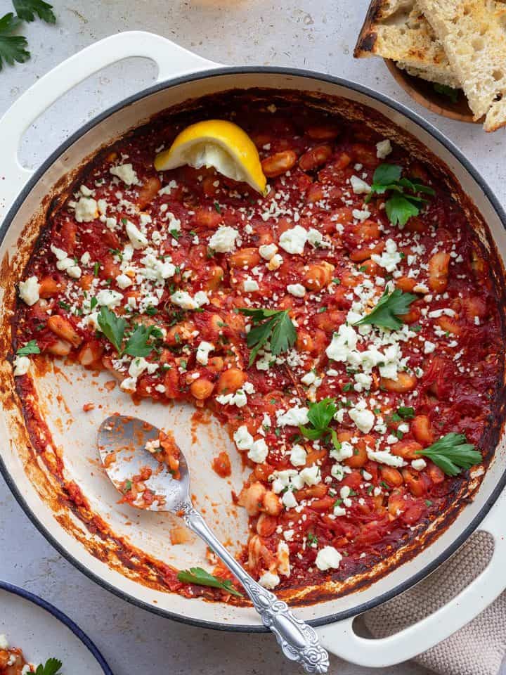 Gigantes Plaki in einer Pfanne mit Feta und Petersilie.