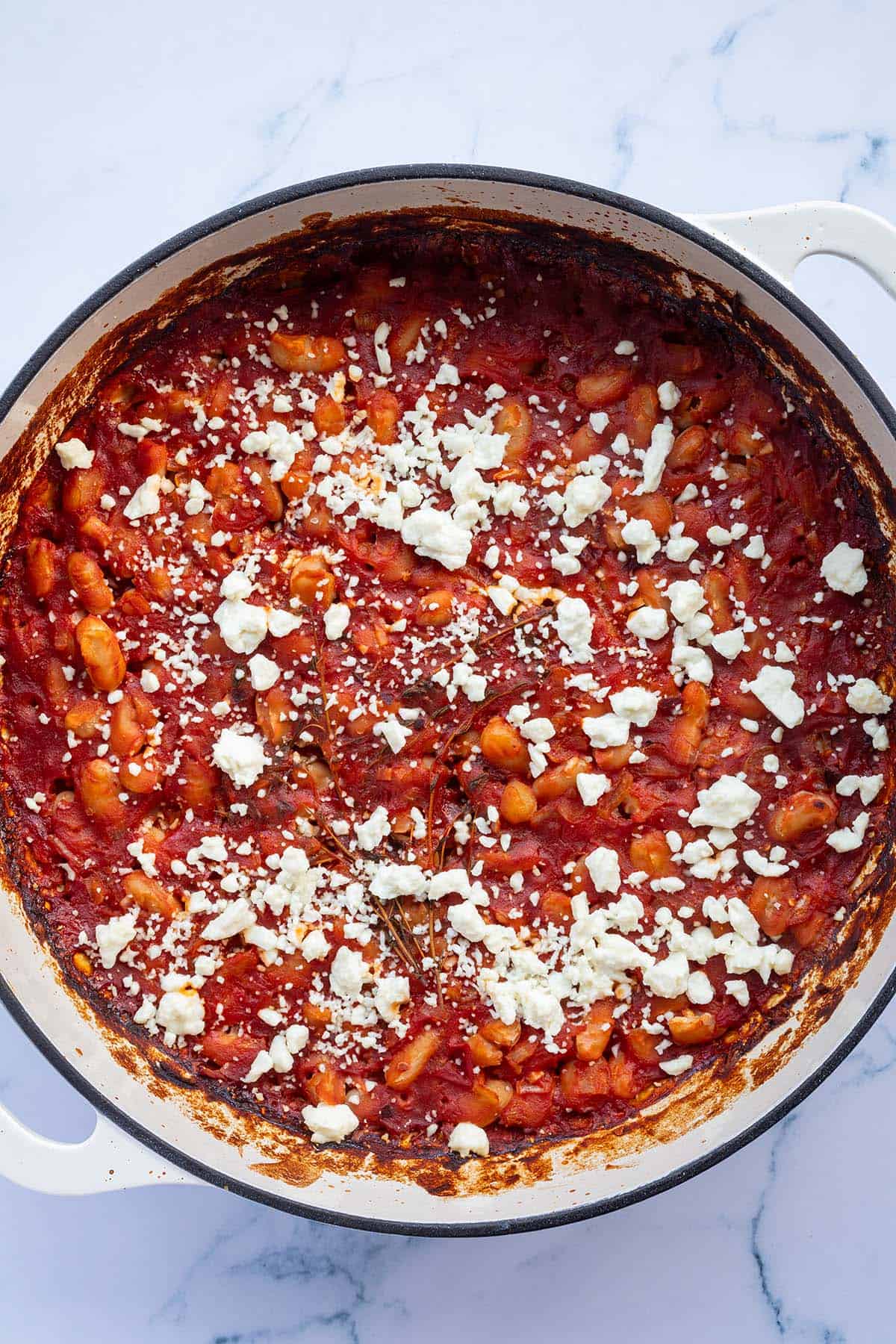 Gebackene Gigantes Plaki mit Feta in einer Pfanne.