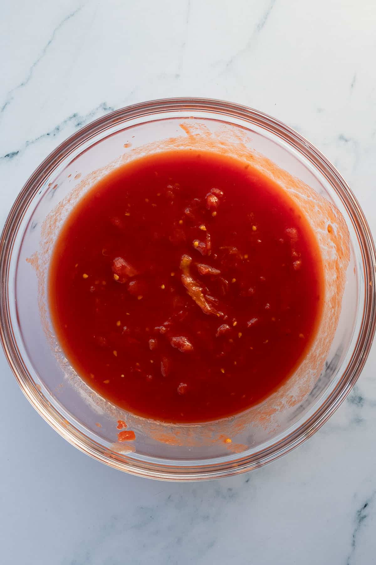 Zerquetschte, gesch&auml;lte Tomaten in einer Glassch&uuml;ssel.