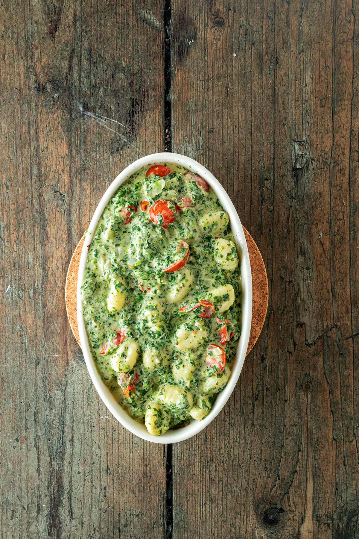Gnocchi in Spinatsauce in einer wei&szlig;en Auflaufform.