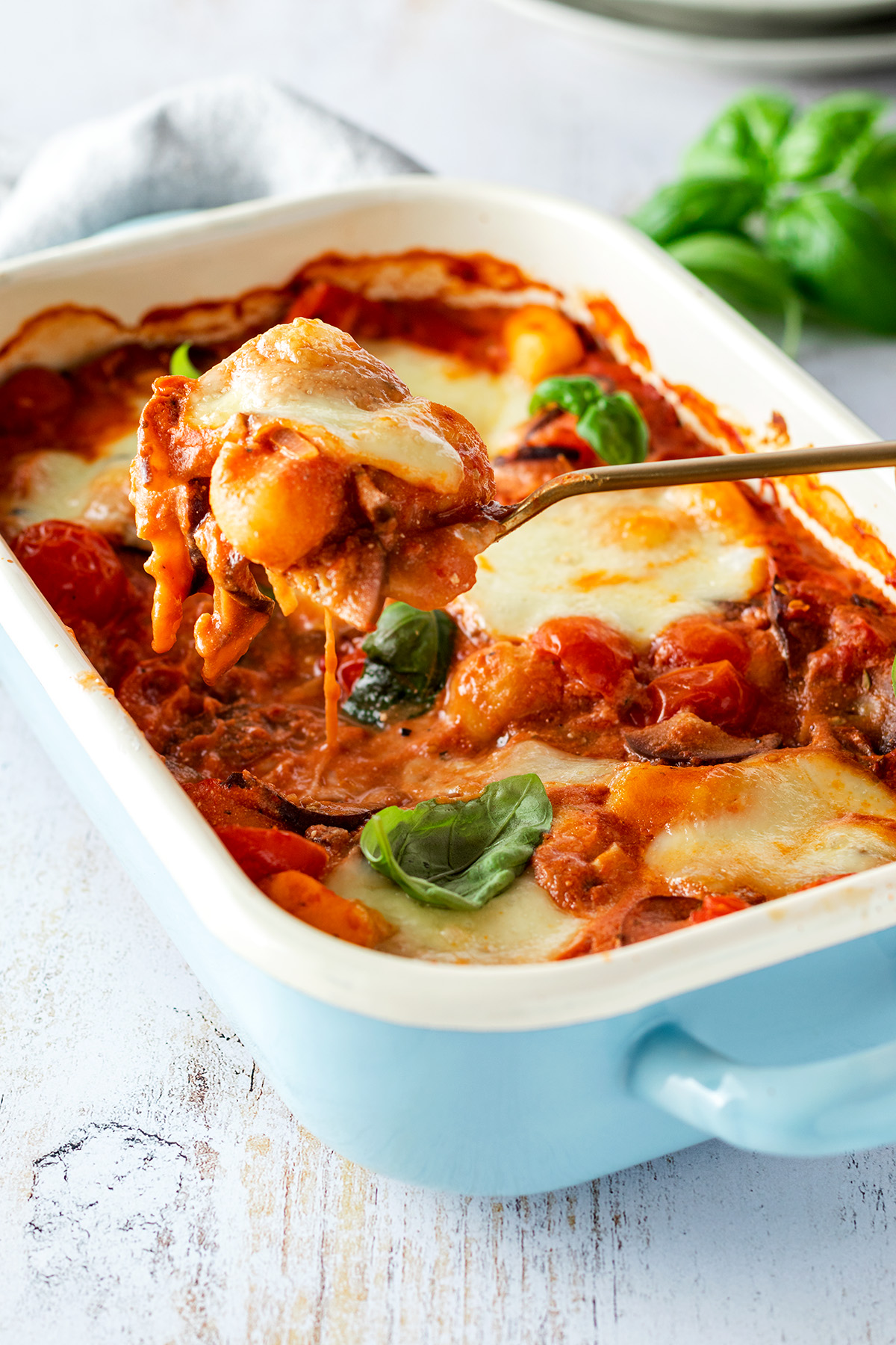 Vegetarischer Gnocchi Auflauf mit Tomate Mozzarella und frischem Basilikum in einer Auflaufform.