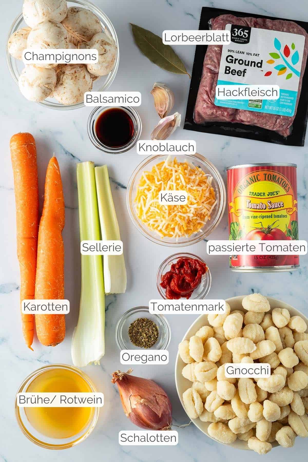 Alle Zutaten mit Textbeschriftungen, die f&uuml;r den Gnocchi Hackfleisch Auflauf ben&ouml;tigt werden.