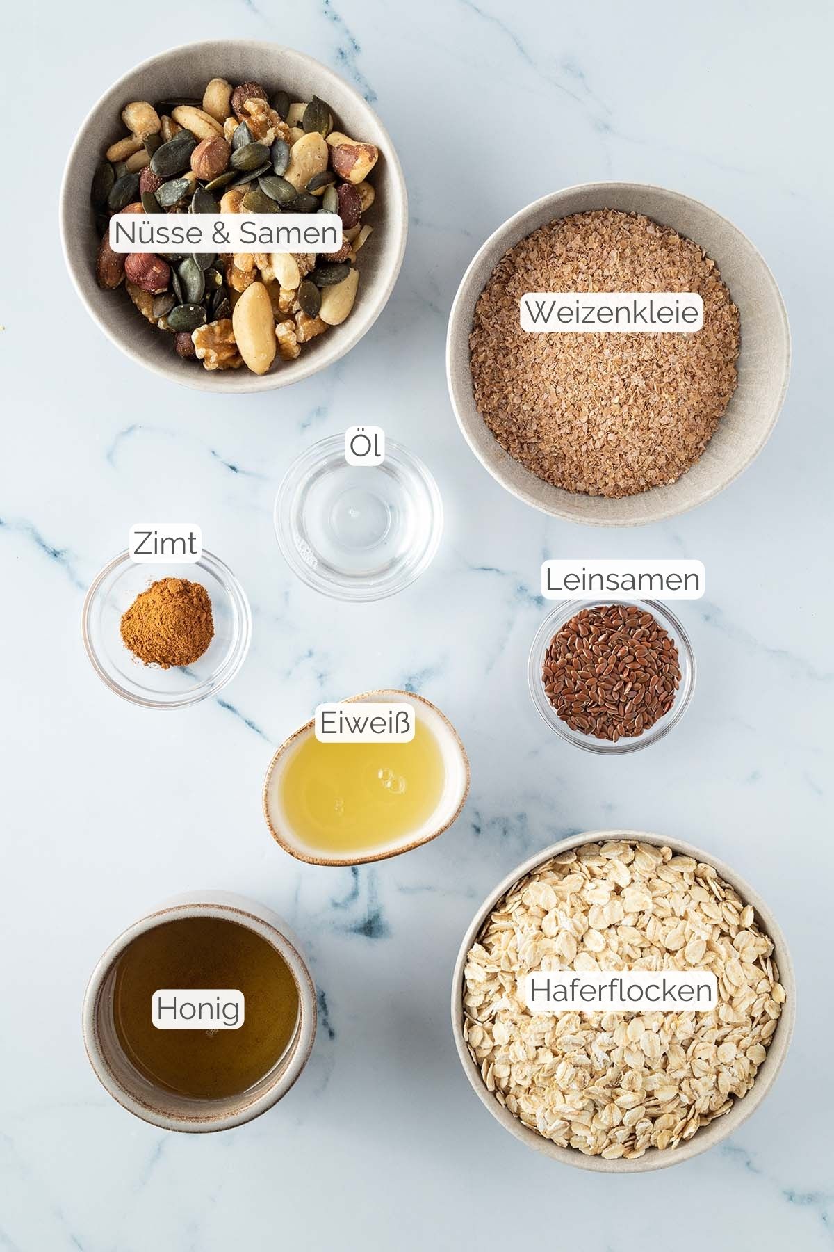 Foto aller Zutaten mit jeweiligen Textbeschriftungen, die f&uuml;r das kalorienarme Garnola ben&ouml;tigt werden.